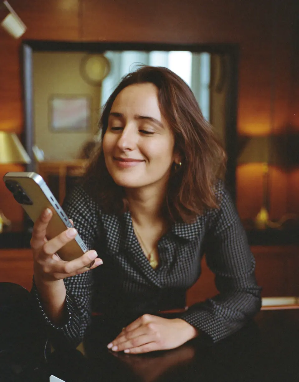 A salon owner smiling at a message on her phone